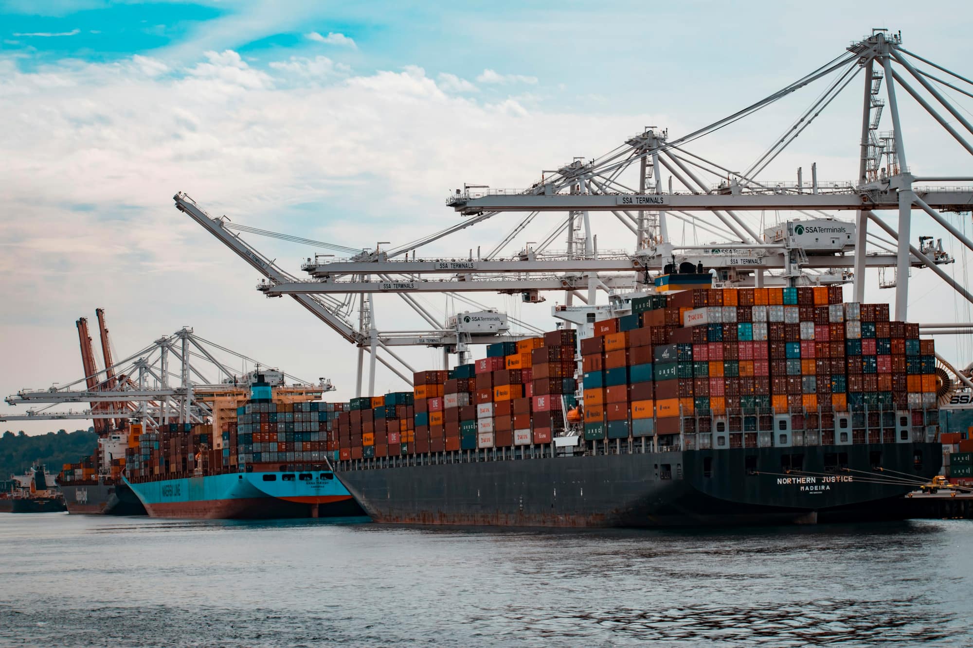 Container ships alongside a terminal under ship-to-shore cranes